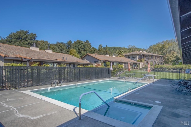 community pool with fence and a patio