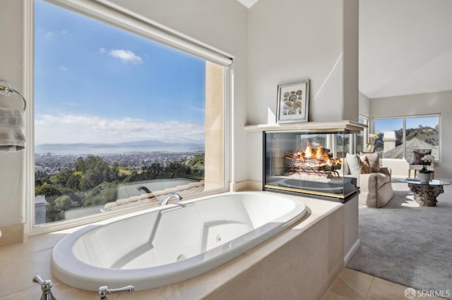 full bath featuring a jetted tub, tile patterned flooring, and a multi sided fireplace