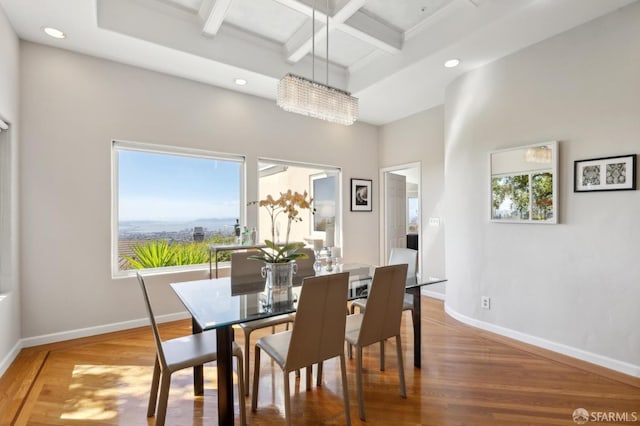 dining space featuring coffered ceiling, wood finished floors, a wealth of natural light, and baseboards