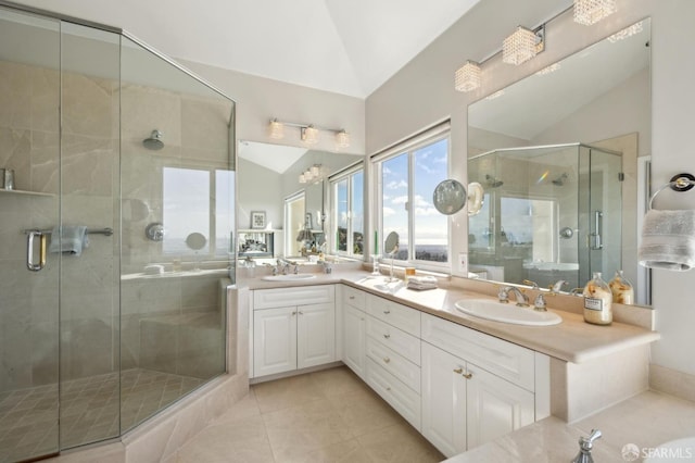 bathroom featuring double vanity, a stall shower, vaulted ceiling, and a sink