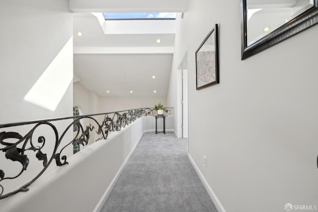 hallway with a skylight, carpet, baseboards, and recessed lighting