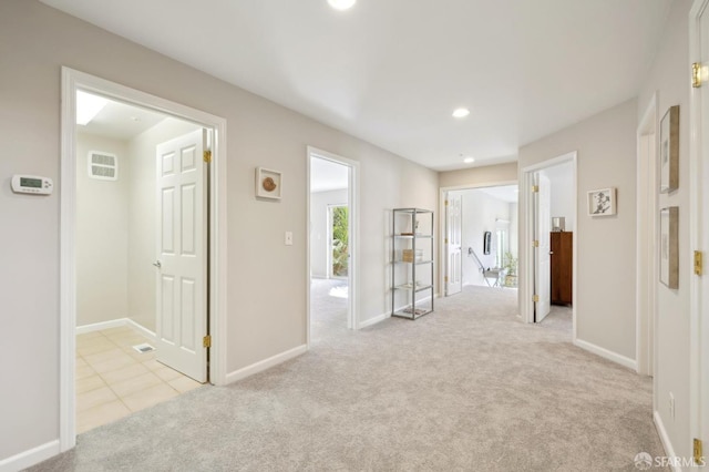 hallway featuring recessed lighting, light colored carpet, a wall unit AC, and baseboards