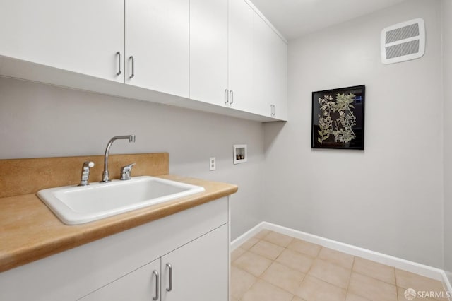 laundry room featuring hookup for a washing machine, cabinet space, visible vents, a sink, and baseboards