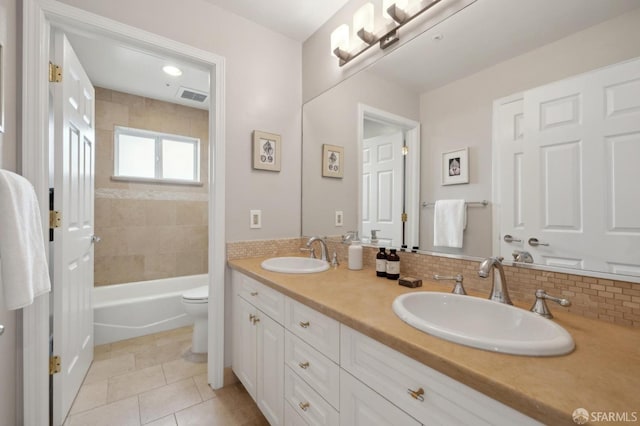 full bathroom featuring toilet, tile patterned flooring, visible vents, and a sink