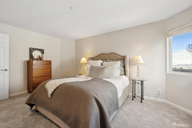 bedroom featuring baseboards and light colored carpet