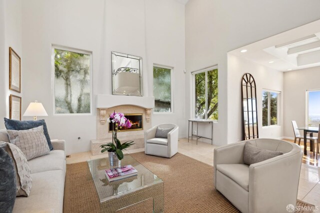 living area with tile patterned flooring, recessed lighting, a high ceiling, and a premium fireplace