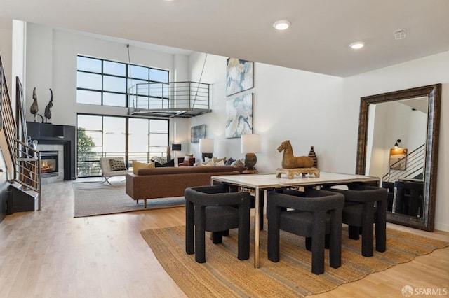 dining space featuring a tile fireplace and light wood-type flooring