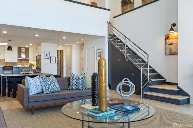 living room with a high ceiling and light hardwood / wood-style flooring