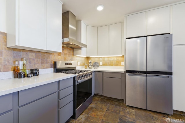 kitchen with gray cabinets, white cabinets, wall chimney range hood, and appliances with stainless steel finishes