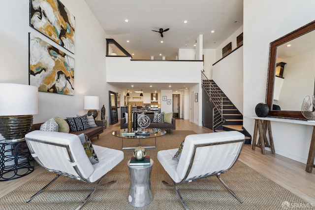 living room featuring light hardwood / wood-style flooring and a high ceiling