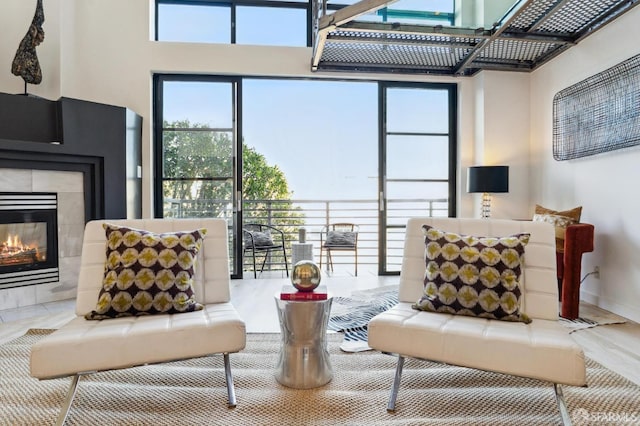 living room with a tiled fireplace, plenty of natural light, and hardwood / wood-style flooring