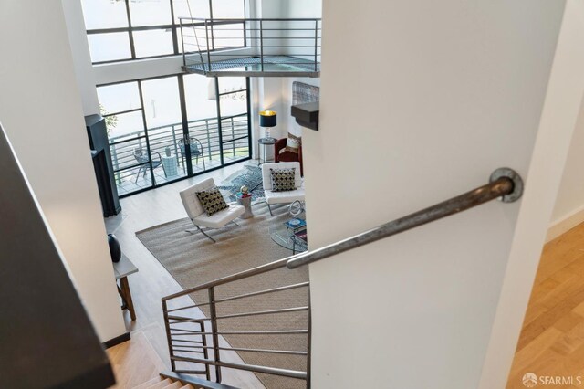 staircase featuring wood-type flooring and a high ceiling