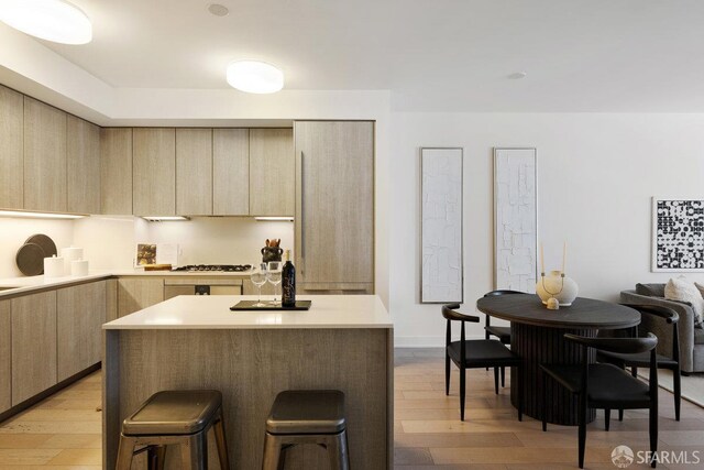 318 Main St Unit 4E, San Francisco, CA 94105 - kitchen with light brown cabinets, modern cabinets, gas cooktop, a kitchen breakfast bar, and light wood finished floors