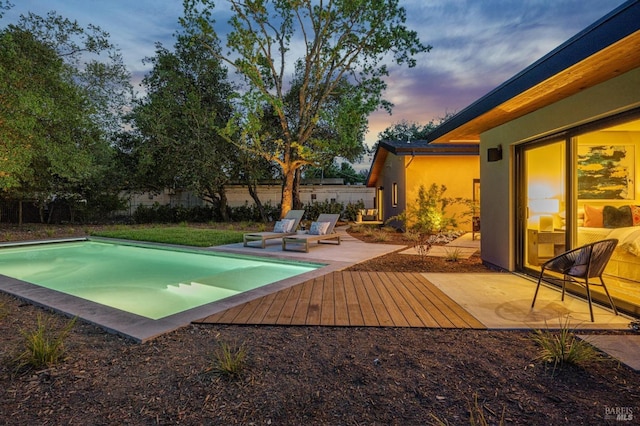 outdoor pool featuring a wooden deck and fence