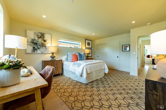 bedroom with light wood-type flooring, a closet, and recessed lighting
