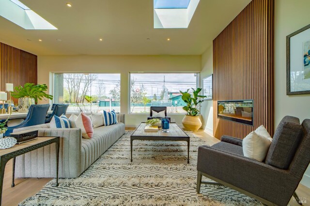 living room featuring a healthy amount of sunlight, recessed lighting, wood finished floors, and a skylight