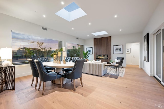 dining area featuring a skylight, recessed lighting, visible vents, and light wood-style floors