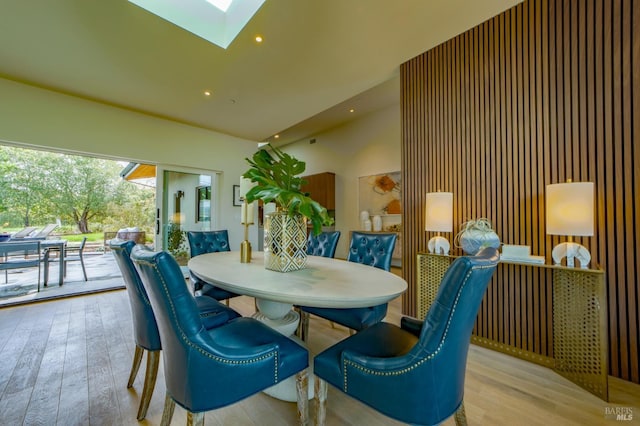 dining space with a skylight, wood finished floors, and recessed lighting
