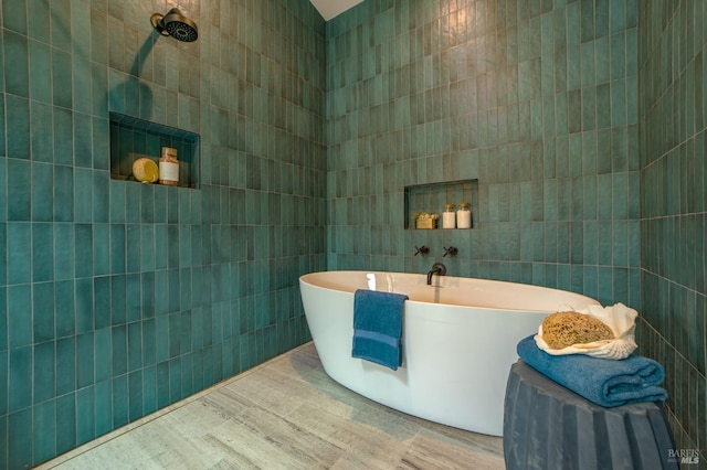 full bath featuring tile walls and a freestanding tub