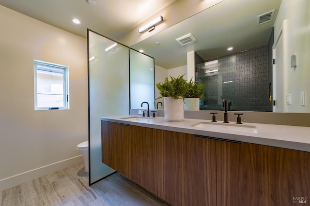 full bath with wood finished floors, a sink, and visible vents