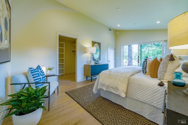 bedroom featuring access to exterior, recessed lighting, wood finished floors, and lofted ceiling
