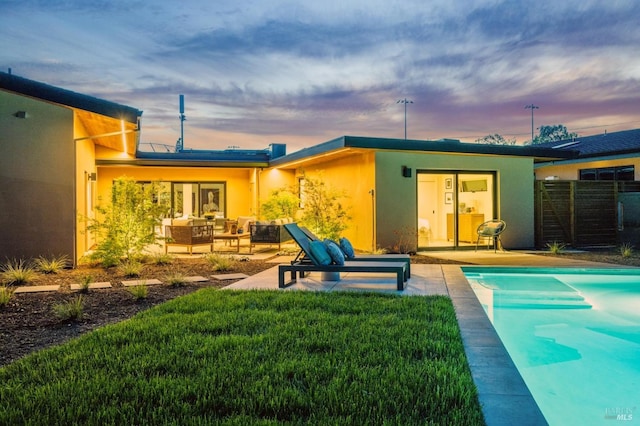 back of house at dusk with an outdoor living space, a patio, stucco siding, and fence