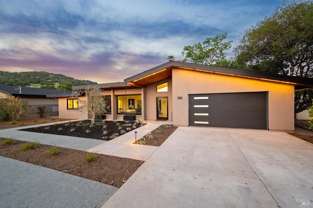 modern home with a garage, driveway, and stucco siding