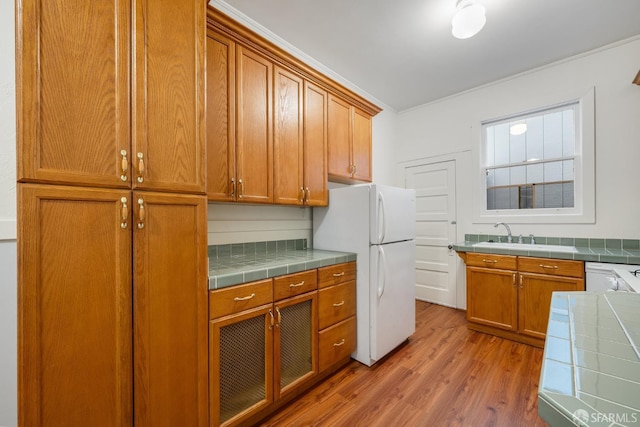 3046-3048 Polk St, San Francisco, CA 94109 - kitchen featuring tile counters, freestanding refrigerator, light wood-style floors, brown cabinetry, and ornamental molding