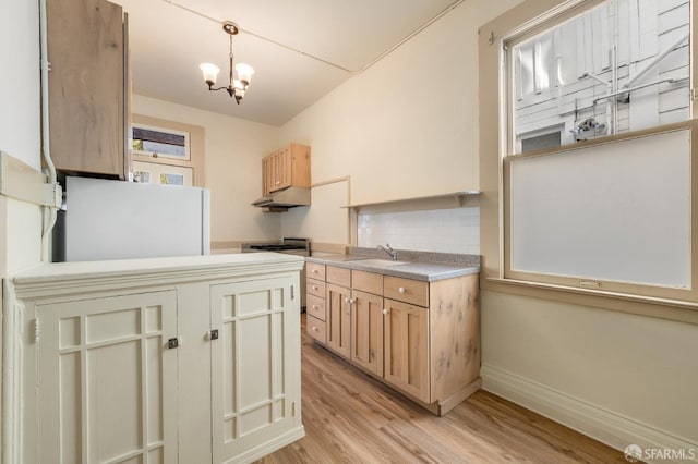 3046-3048 Polk St, San Francisco, CA 94109 - kitchen featuring stove, fridge, under cabinet range hood, light wood-type flooring, and tasteful backsplash