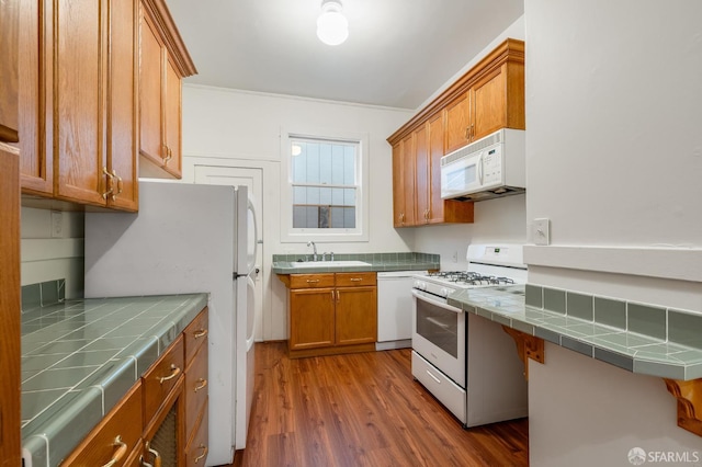 3046-3048 Polk St, San Francisco, CA 94109 - kitchen featuring white appliances, tile countertops, wood finished floors, and brown cabinets