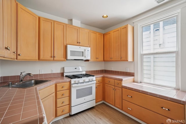 3046-3048 Polk St, San Francisco, CA 94109 - kitchen featuring white appliances, tile counters, light brown cabinets, and recessed lighting