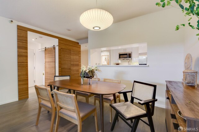 dining space featuring wood finished floors and baseboards