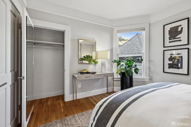 bedroom featuring a closet, baseboards, and wood finished floors