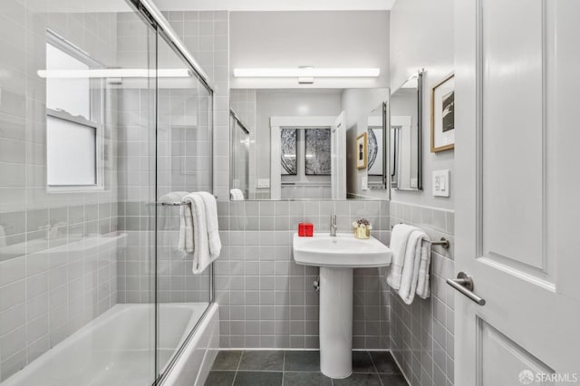 full bathroom with shower / bath combination with glass door, tile walls, and tile patterned flooring