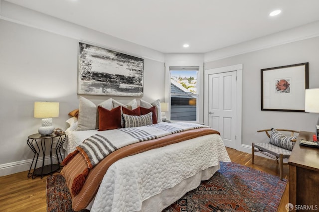 bedroom with baseboards, recessed lighting, and wood finished floors