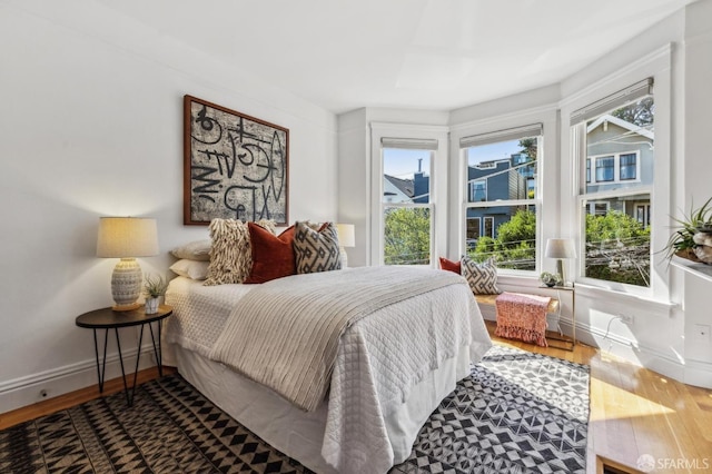 bedroom with baseboards and wood finished floors