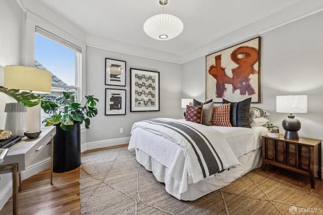 bedroom featuring wood finished floors and baseboards