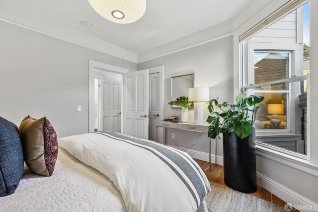 bedroom featuring baseboards and wood finished floors