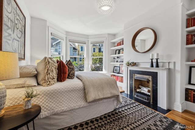 bedroom featuring wood finished floors and a fireplace