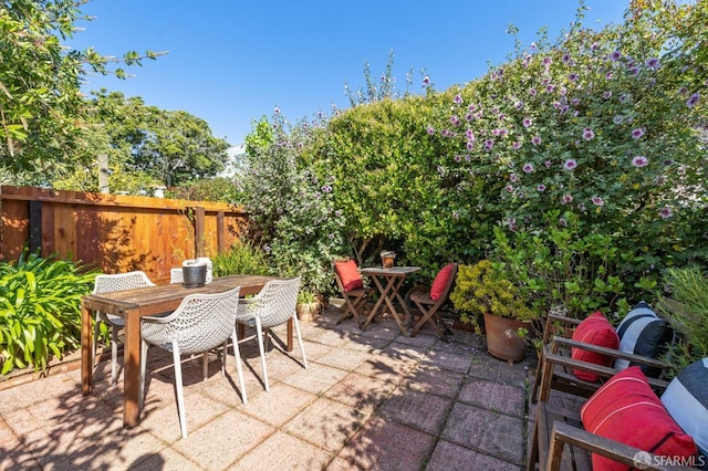 view of patio with outdoor dining space and fence