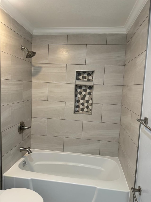 bathroom featuring ornamental molding, toilet, and tiled shower / bath