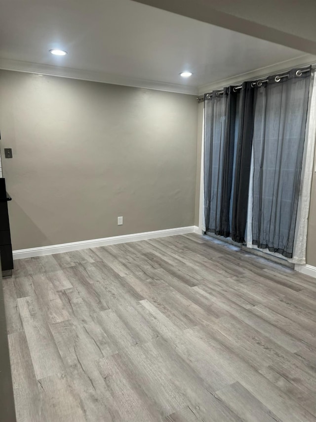 spare room with light hardwood / wood-style floors and crown molding