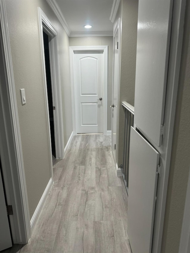 corridor featuring light wood-type flooring and crown molding