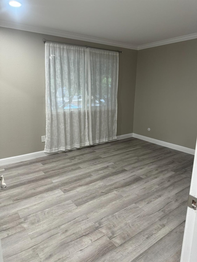 spare room with crown molding and light hardwood / wood-style flooring