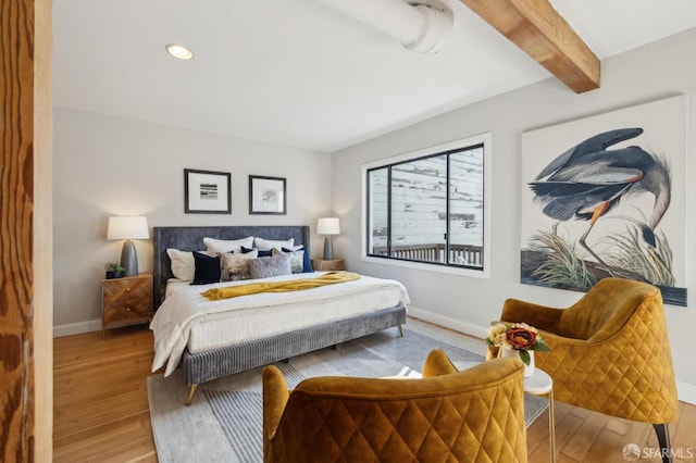 bedroom with hardwood / wood-style flooring and beamed ceiling