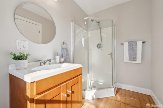 bathroom featuring a shower with shower door, wood-type flooring, and vanity