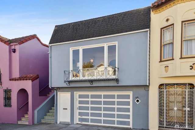 view of front of home featuring a garage and a balcony