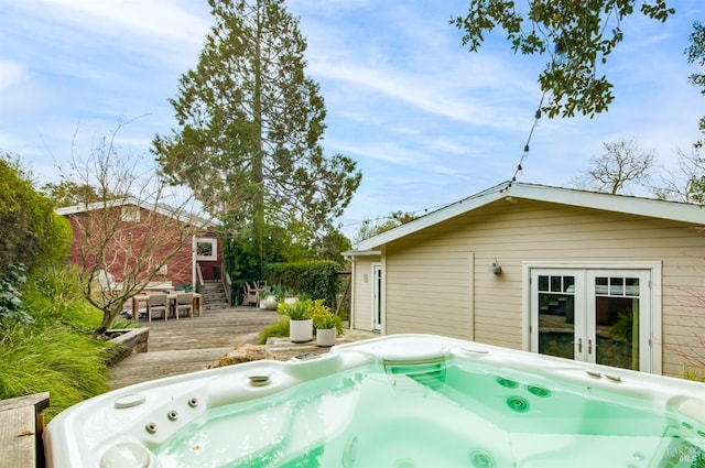 exterior space with a wooden deck, entry steps, a hot tub, and french doors