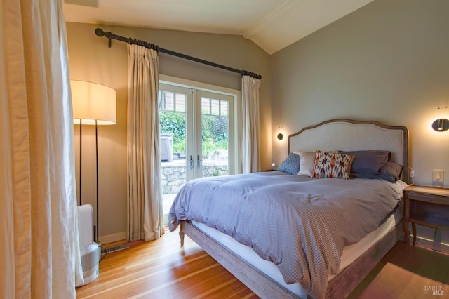 bedroom featuring visible vents, vaulted ceiling with beams, french doors, wood finished floors, and access to outside