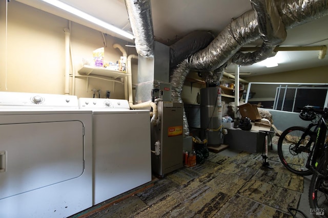 laundry room with laundry area, gas water heater, and washing machine and clothes dryer